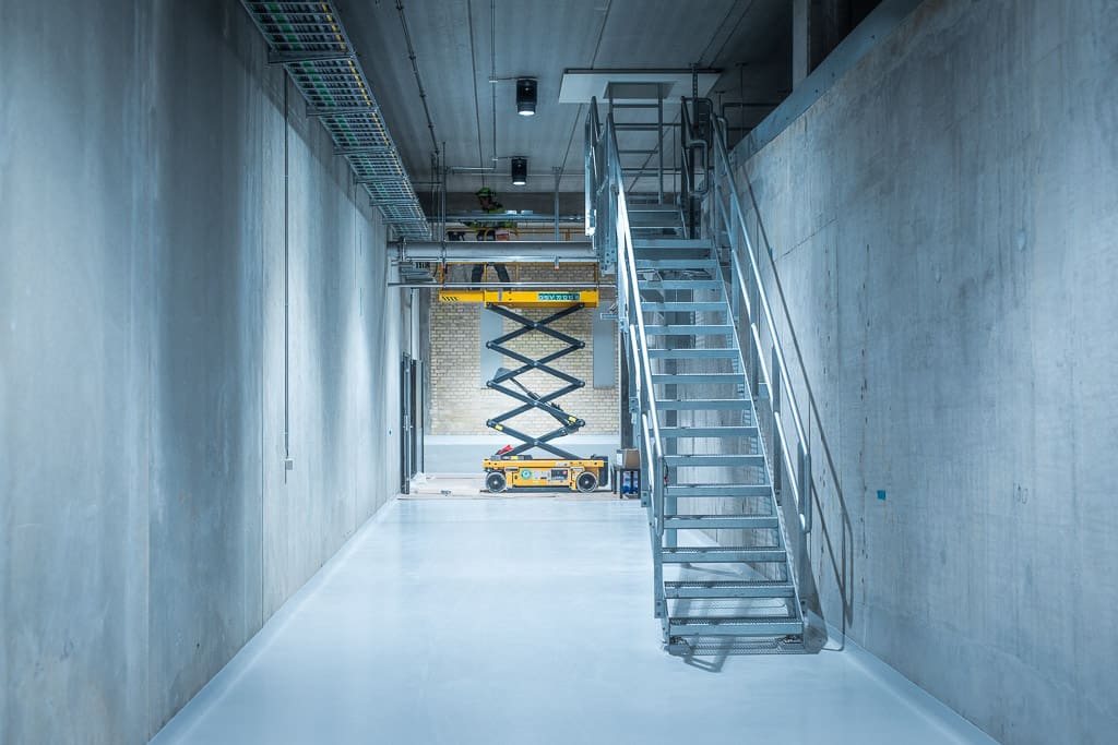 Indoor concrete corridor with a steel staircase under construction